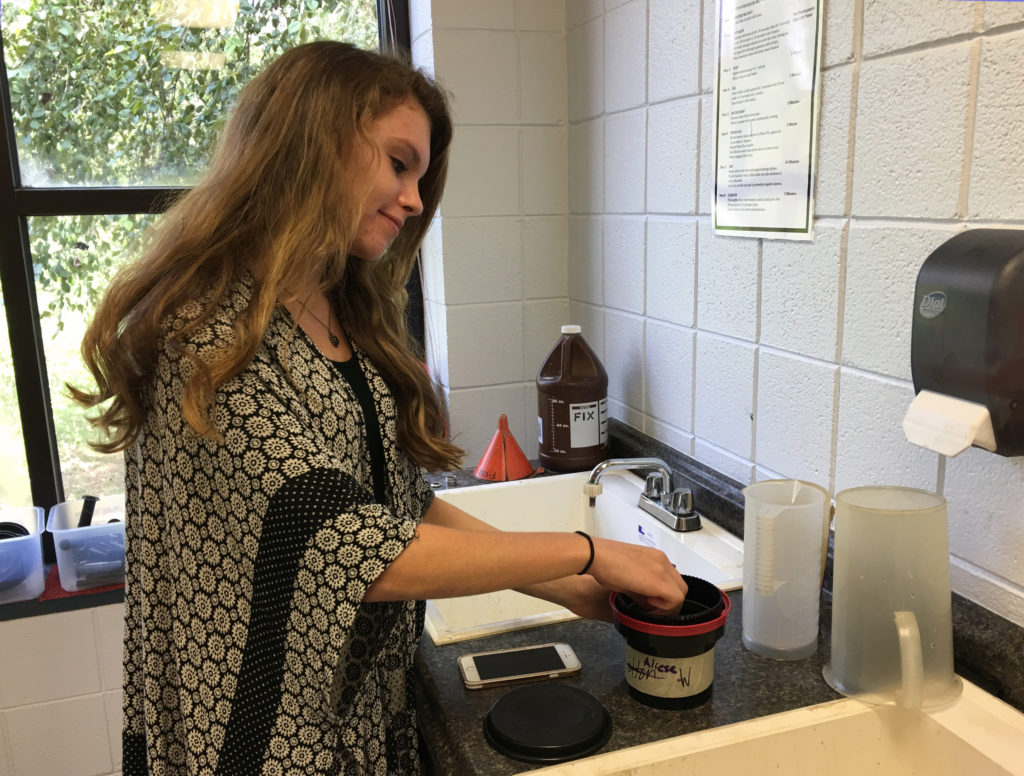 Sophomore Aliese White developing a roll of black-and-white film.