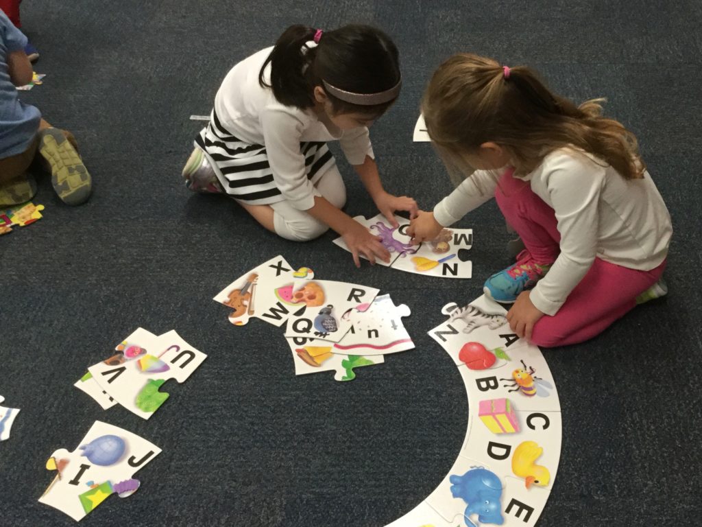 TK students work together to solve a puzzle.